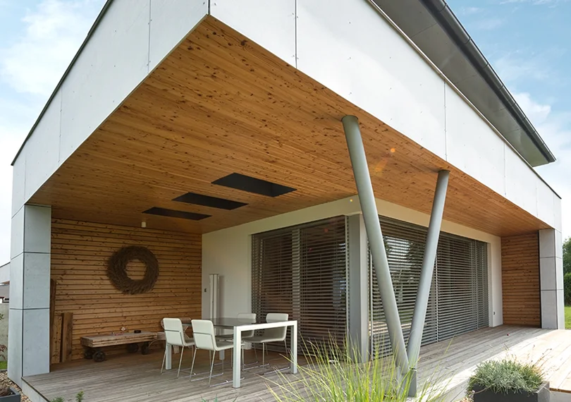 Modernes Haus mit Holzterrasse und Raffstores aus Aluminium