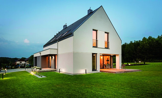 Modernes Einfamilienhaus mit großen Fenstern und Pultdach auf gepflegtem Rasen