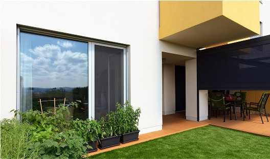 Mehrfamilienhaus mit Insektenschutz an der Schiebetür und beschatteter Terrasse