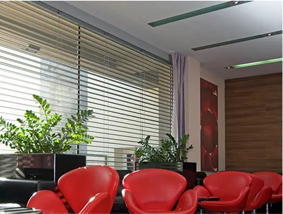 Moderner Wartebereich mit roten Sesseln und Horizontaljalousien aus Aluminium