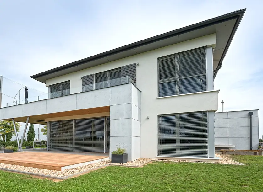 Modernes Einfamilienhaus mit großen Fenstern und Raffstores aus Aluminium