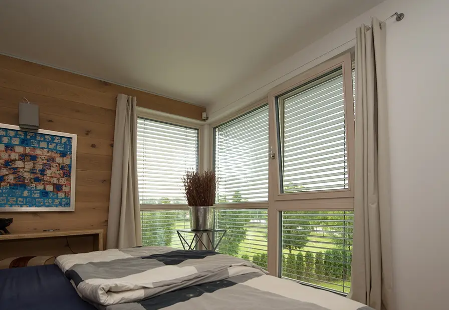 Schlafzimmer mit Eckfenstern und Raffstores aus Aluminium